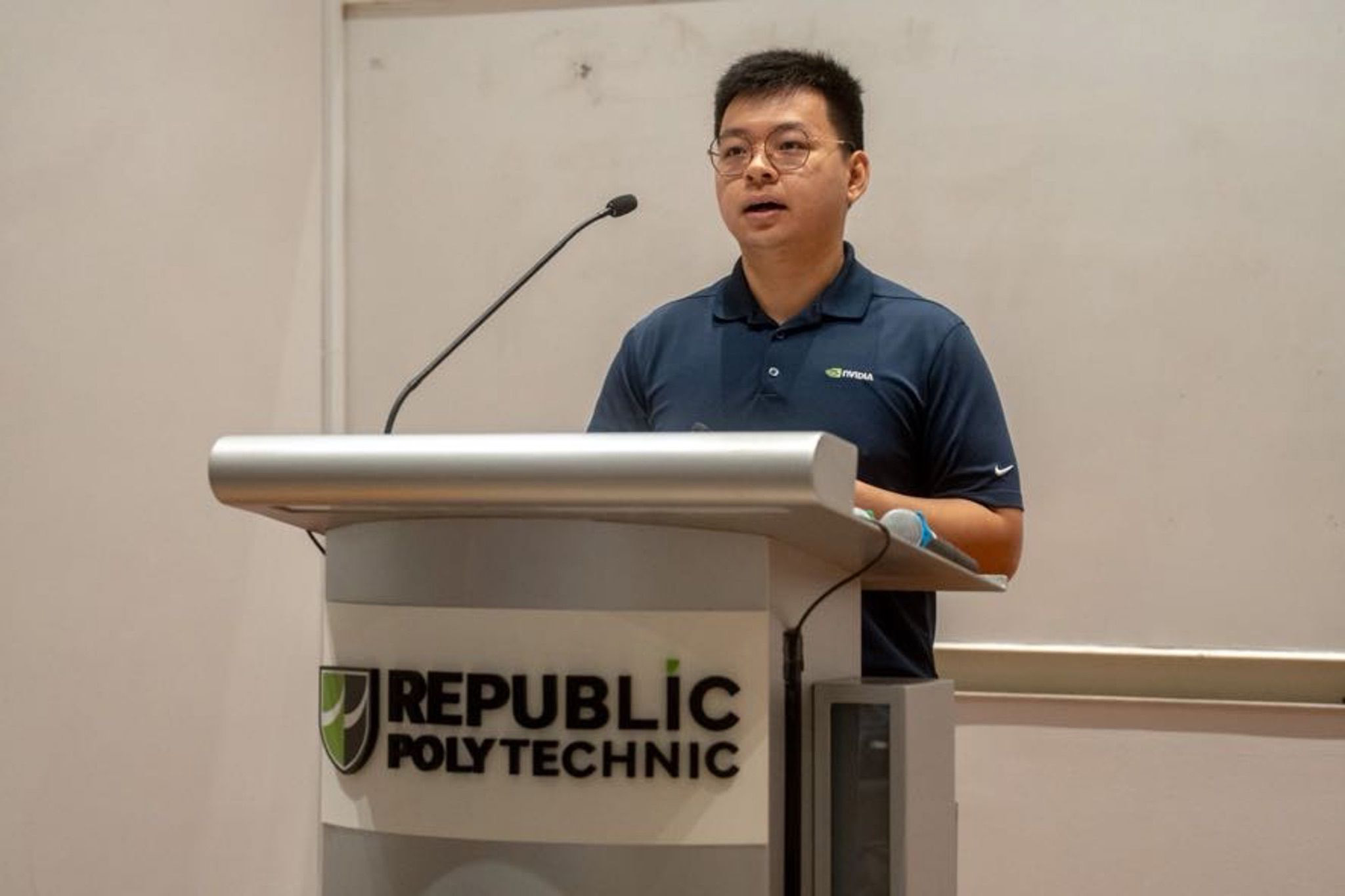 Timothy Liu speaking at a Republic Polytechnic podium during an invited talk