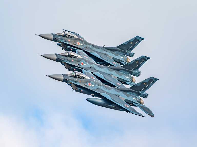 Three Mitsubishi F-2A aircraft from the 8th Tactical Fighter Squadron fly in formation at Tsuiki Air Base.